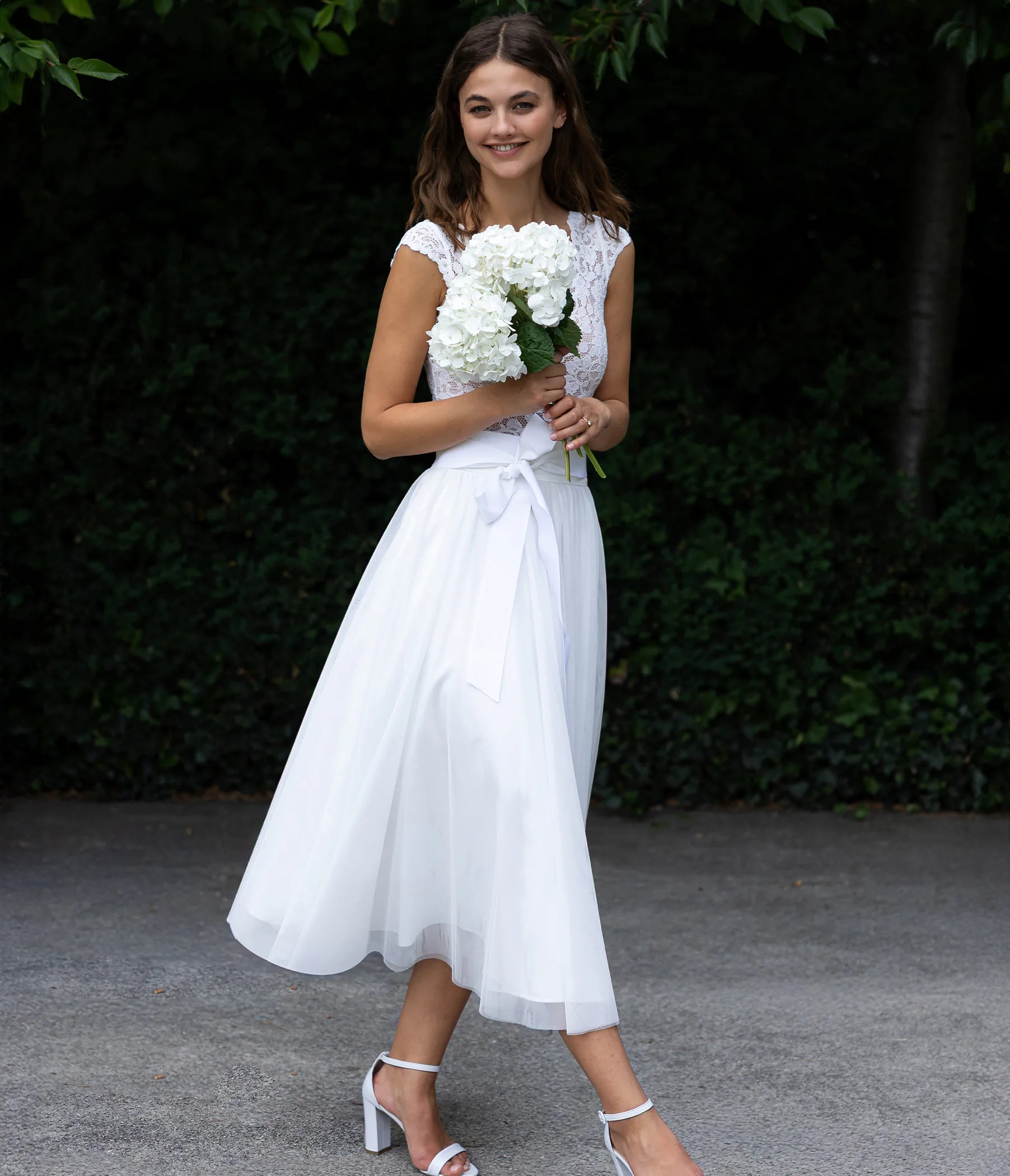 Brautkleid im Boho Stil mit Spitzenbody und wadenlanger Tüllrock in der Natur fotografiert