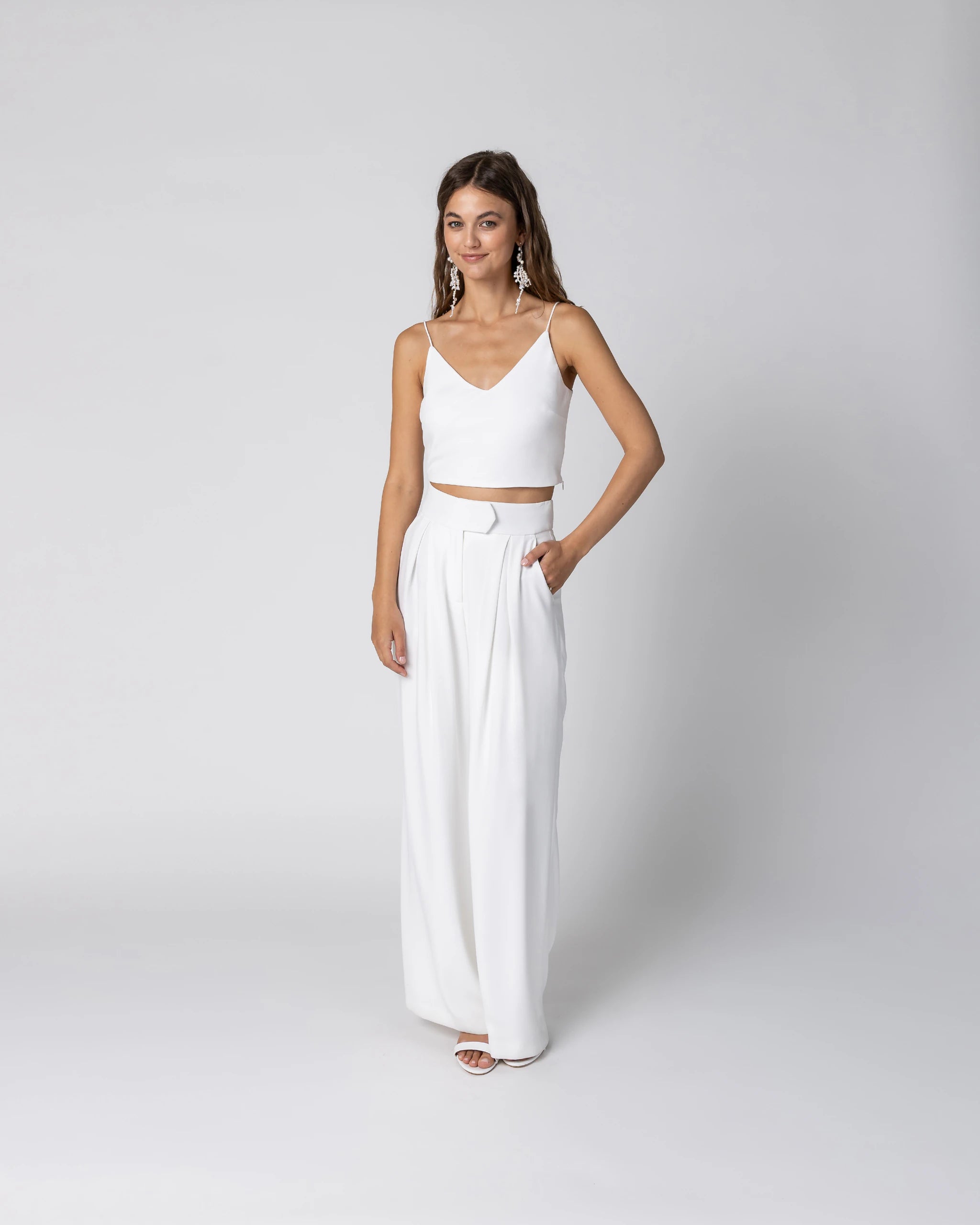 Braut in modernem Braut Jumpsuit mit Bralette Top und weiter Marlene Hose in Ivory Ansicht vorne
