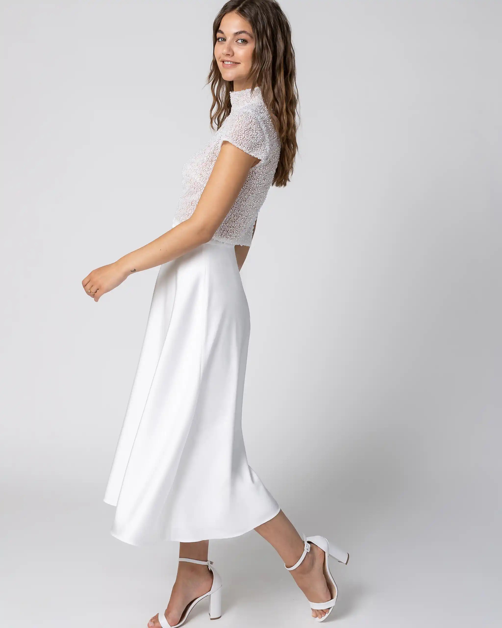 Braut in modernem Standesamtkleid mit hochgeschlossenem Spitzenoberteil und midiweissem Satinrock seitlich