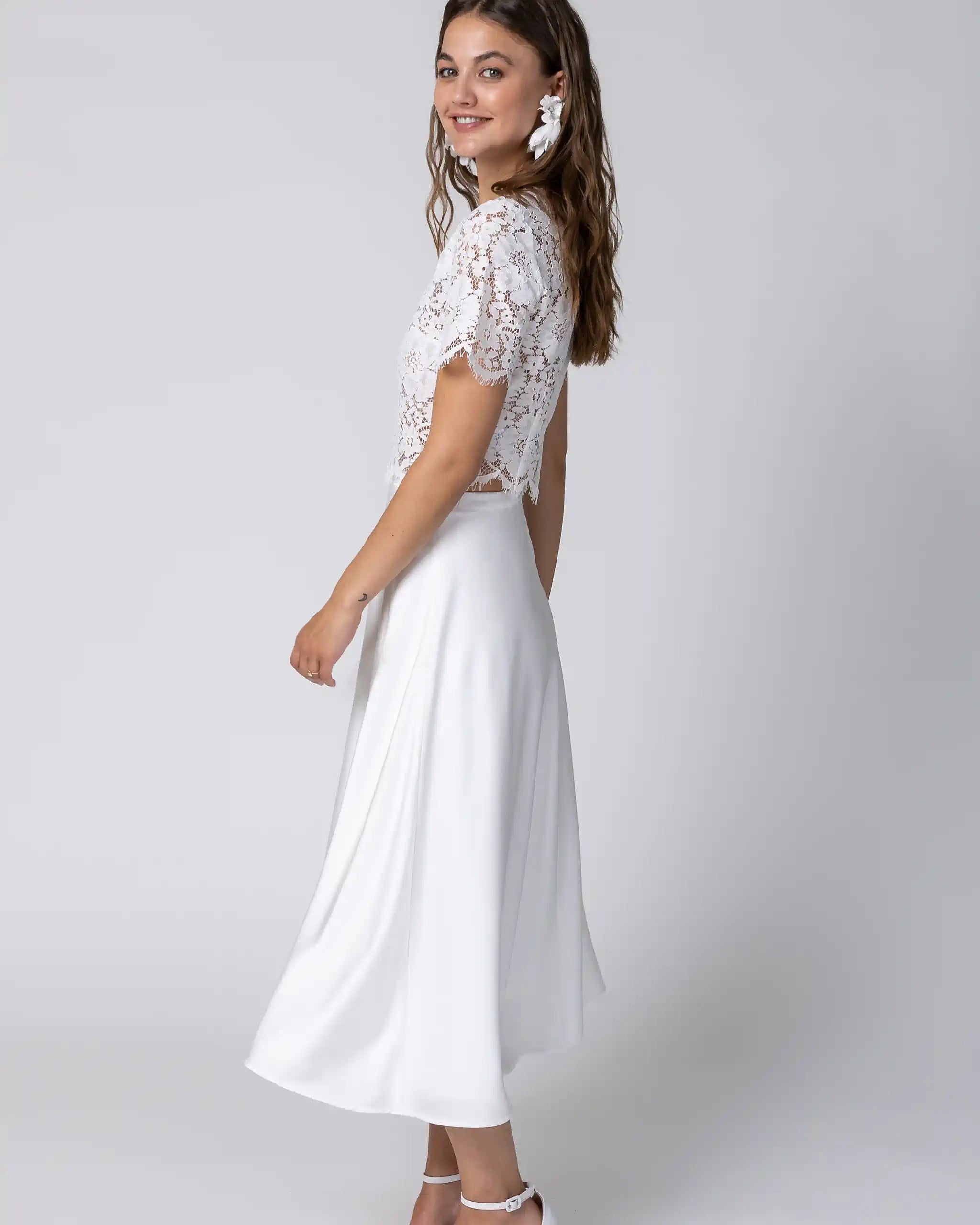 Braut in Standesamtkleid mit floralem Spitzenoberteil und fliessendem Midi Satinrock Ansicht seitlich