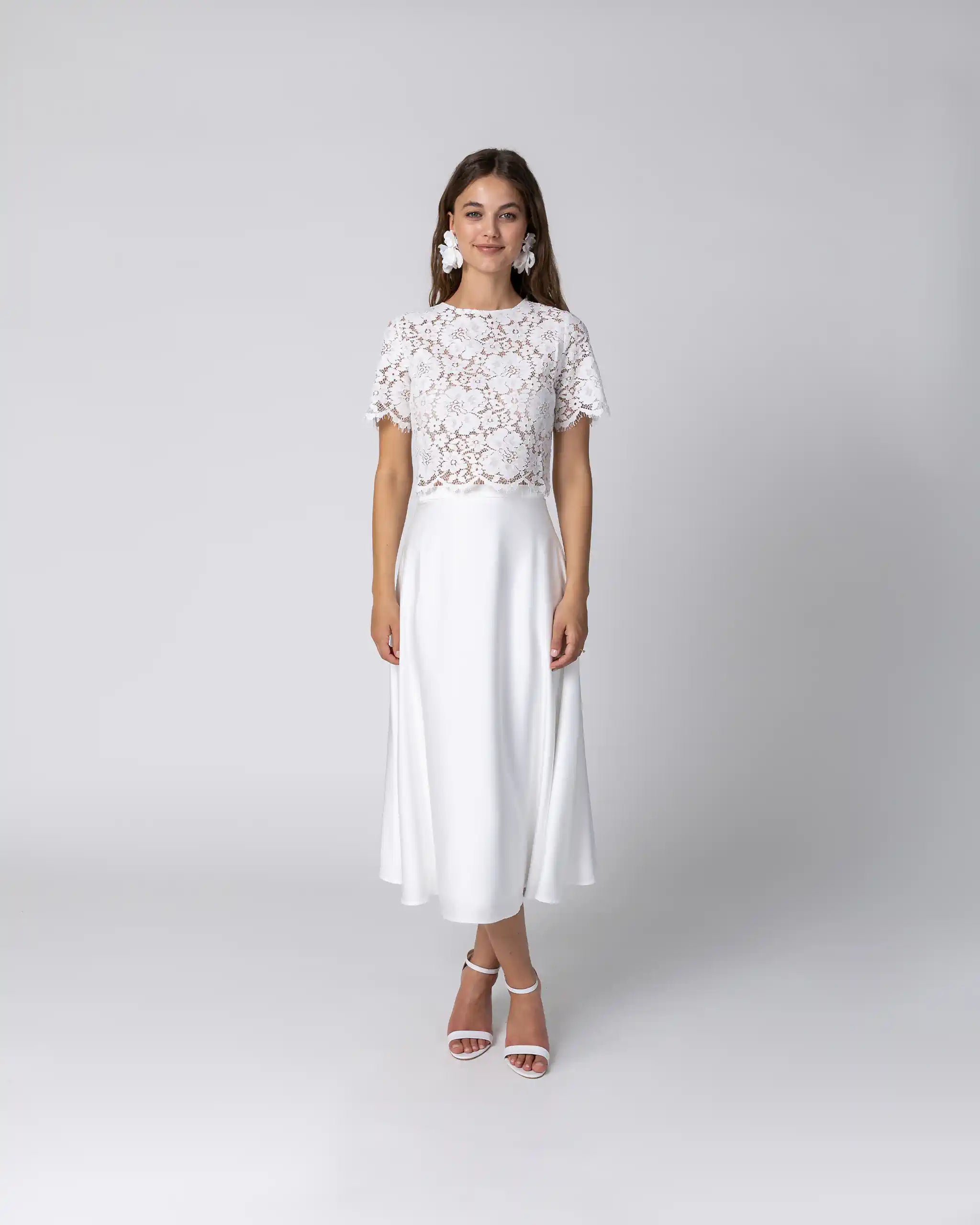 Braut in Standesamtkleid mit floralem Spitzenoberteil und fliessendem Midi Satinrock Ansicht vorne