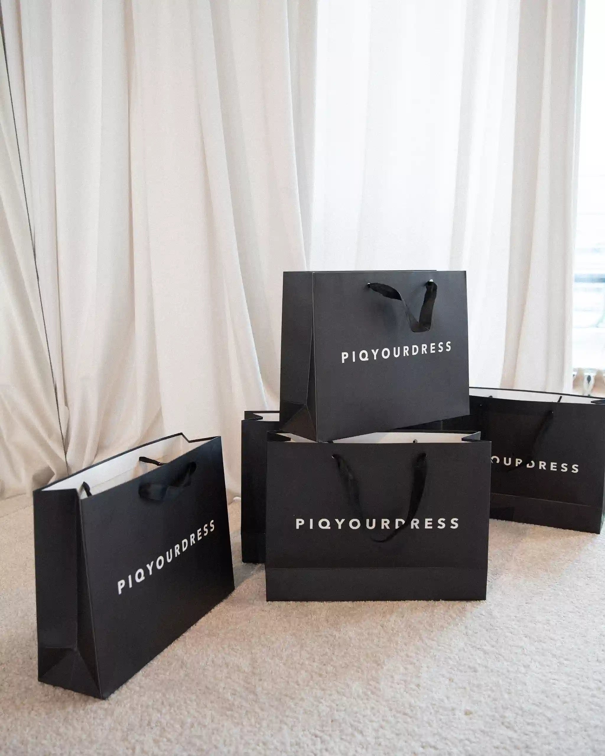 Gutschein piqyourdress moderne Abend und Brautmode - Einkaufstüten im Showroom