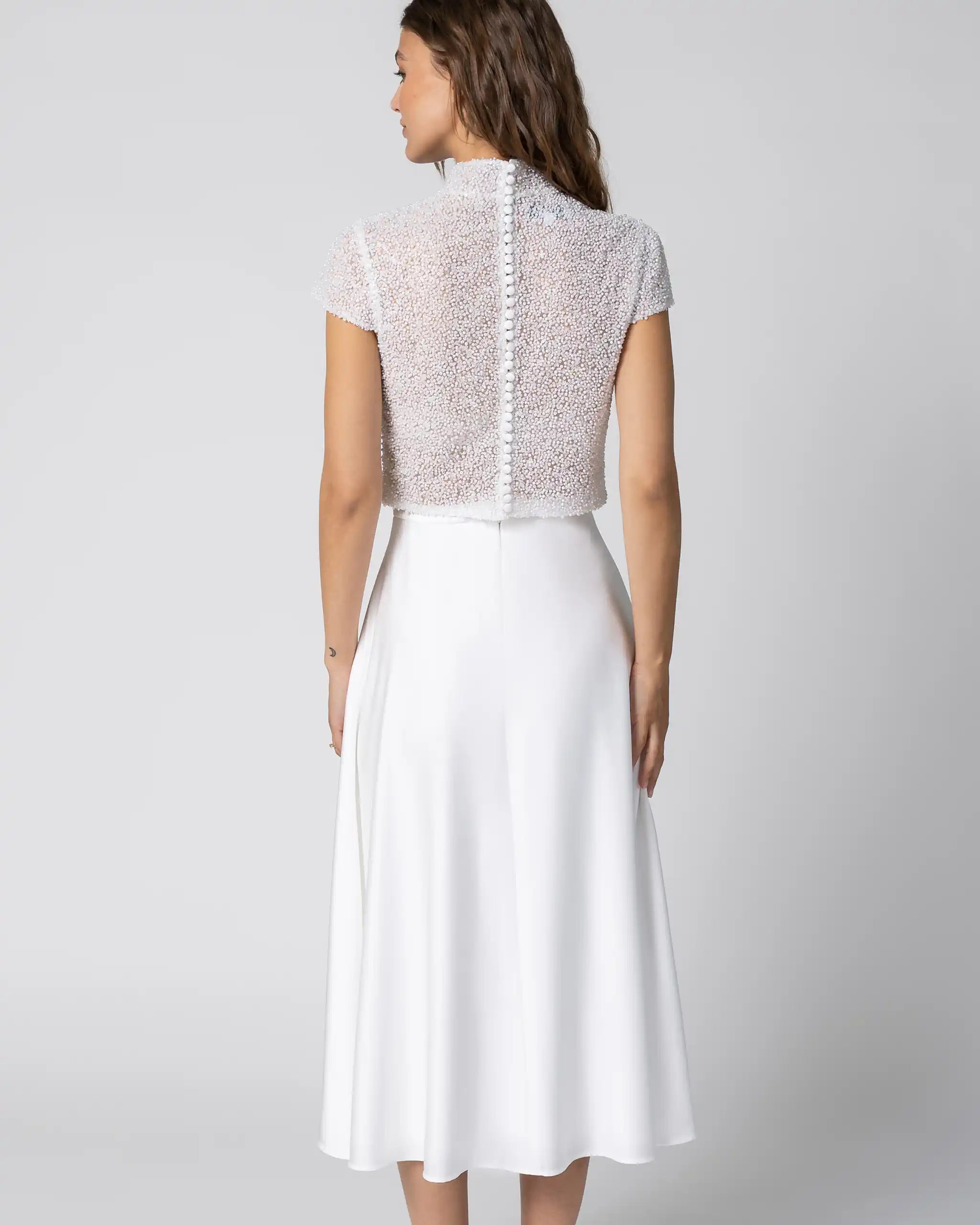 Braut in modernem Standesamtkleid mit hochgeschlossenem Spitzenoberteil und midiweissem Satinrock Ansicht hinten
